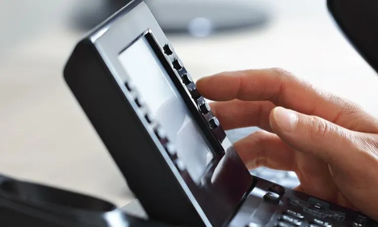 Hand bedient een zakelijke vaste telefoon